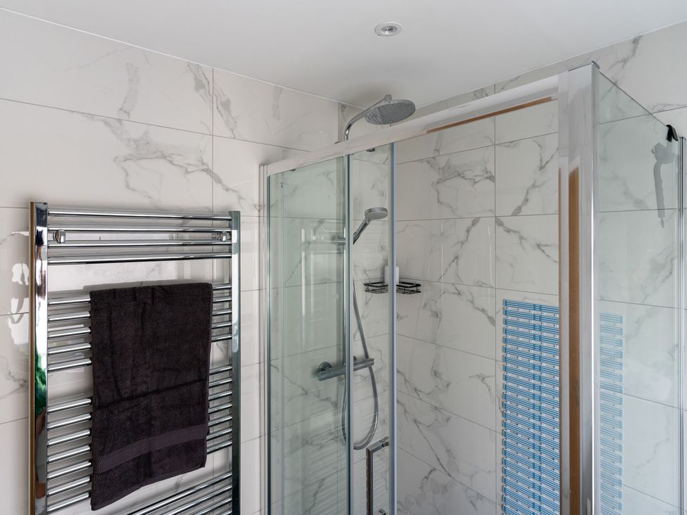 A bathroom with a shower and towel rail at Shepherd's Lodge in Skipton