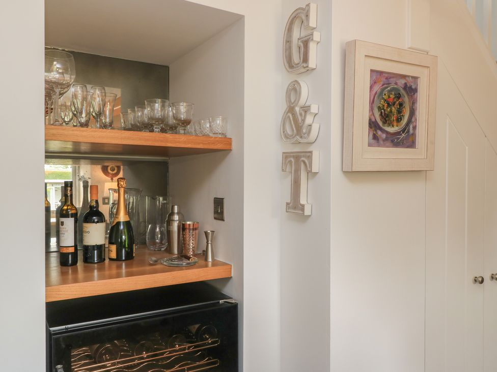 A bar area with bottles and glasses at The Cottage in Ashton Keynes