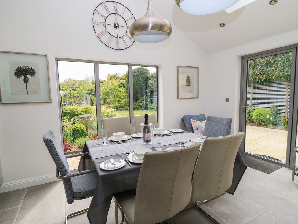 A dining room with a table set for a meal at The Cottage in Ashton Keynes