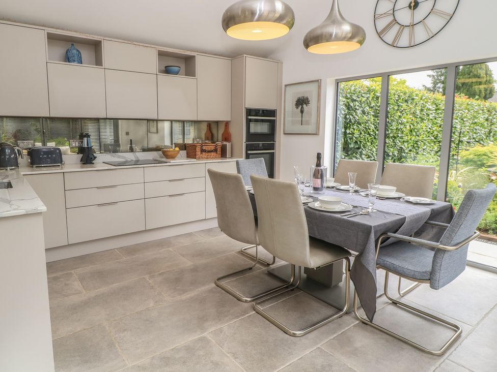 A kitchen with a dining table and chairs at The Cottage in Ashton Keynes