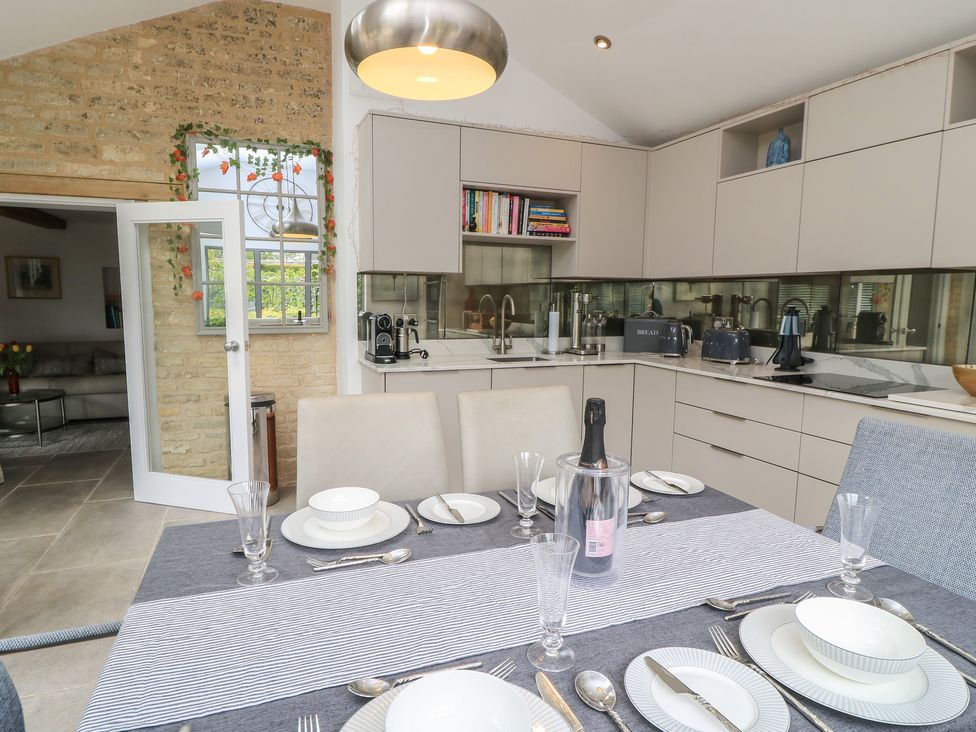 A kitchen with a dining table set at The Cottage in Ashton Keynes