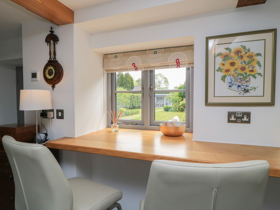 A kitchen area with a table and chairs at The Cottage in Ashton Keynes
