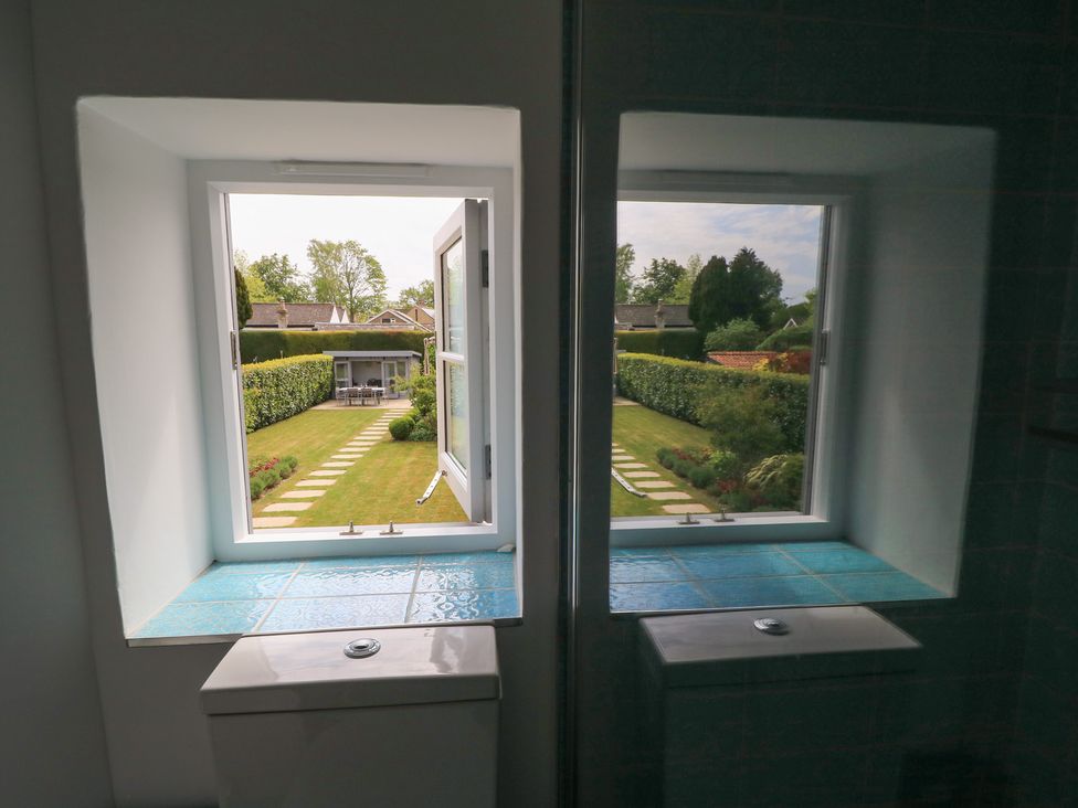 A window view of a garden with a path at The Cottage in Ashton Keynes