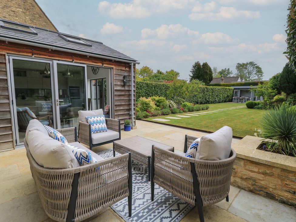 A patio with seating area and garden at The Cottage in Ashton Keynes