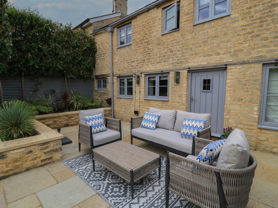 A garden with outdoor seating and a coffee table at The Cottage in Ashton Keynes