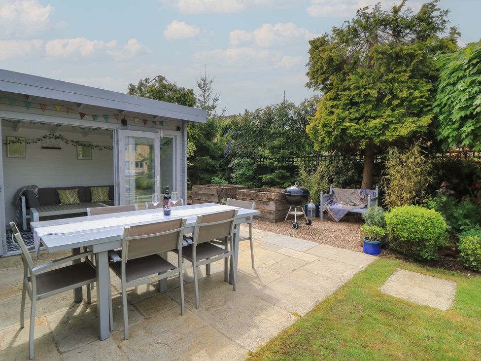 A garden with a dining table and chairs at The Cottage in Ashton Keynes