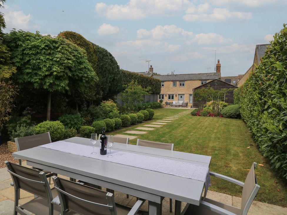 A garden with a table and chairs at The Cottage in Ashton Keynes