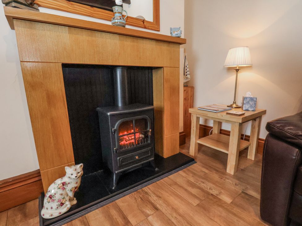 A living room with a fireplace and wood stove at 2 High Stakesby Cottages in Whitby