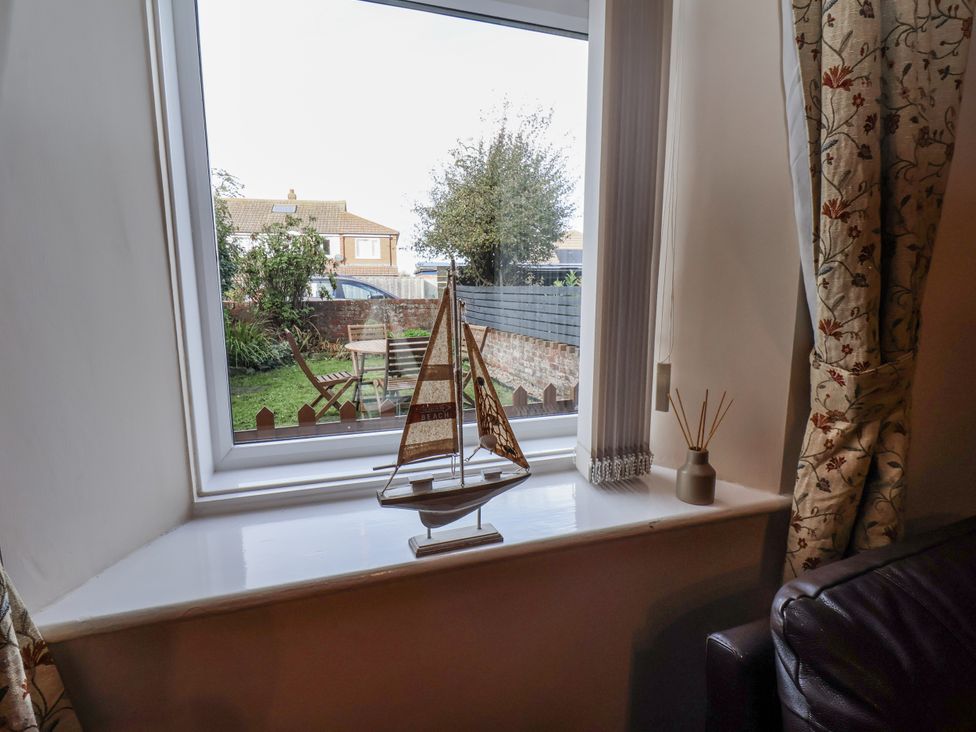 A living room with a window view of a garden at 2 High Stakesby Cottages in Whitby