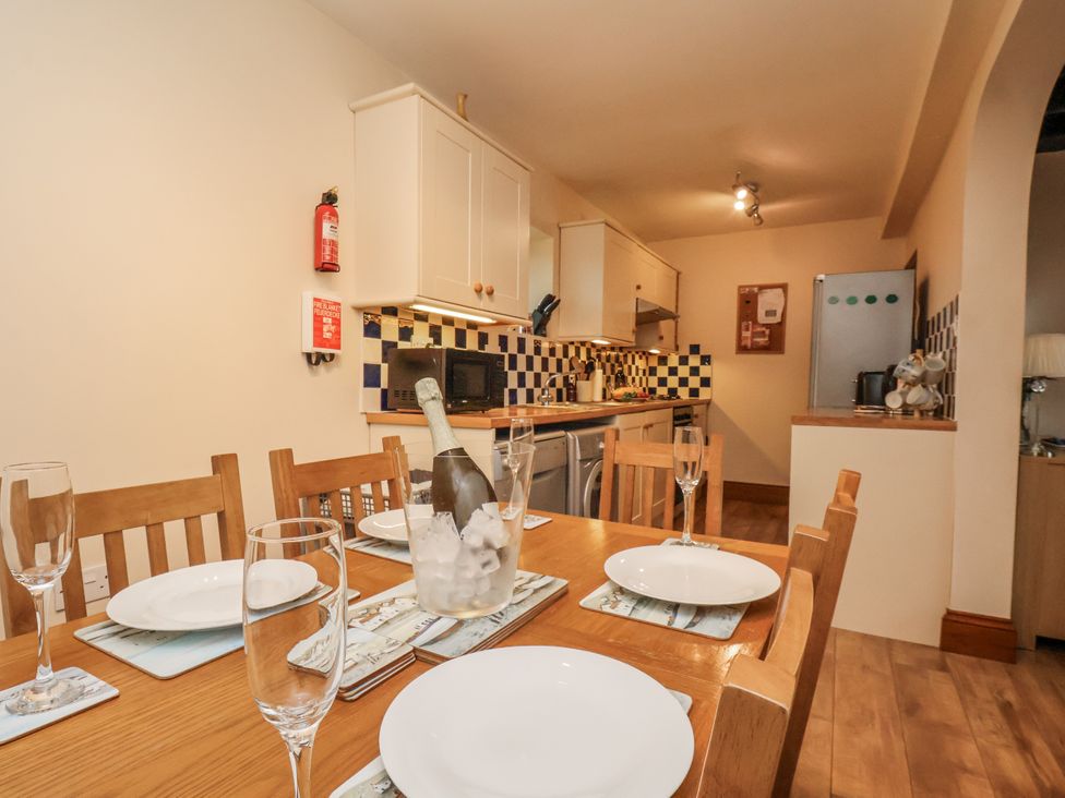 A kitchen with a dining table and equipment at 2 High Stakesby Cottages in Whitby