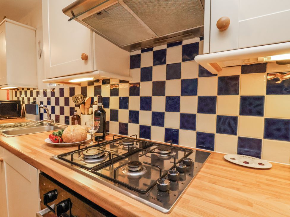 A kitchen with a gas stove and sink at 2 High Stakesby Cottages Whitby