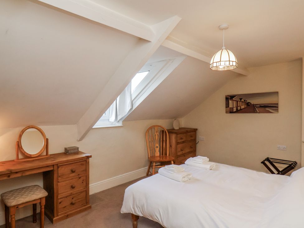 A bedroom with a bed and a dressing table at 2 High Stakesby Cottages in Whitby