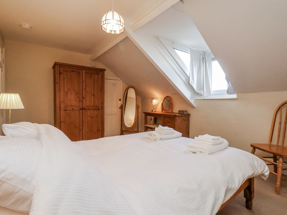 A bedroom with a bed and wardrobe at 2 High Stakesby Cottages in Whitby