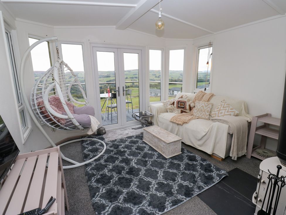 A conservatory with a hanging chair and couch at John's Folly