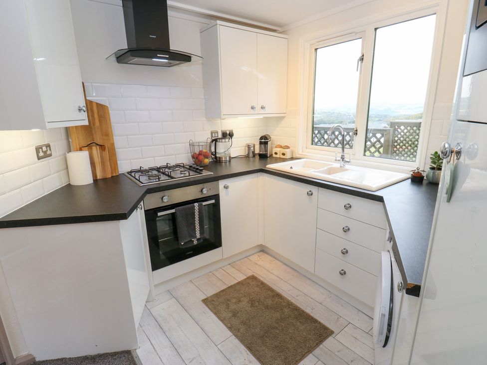 A kitchen with cabinets, sink, and cooker at John's Folly