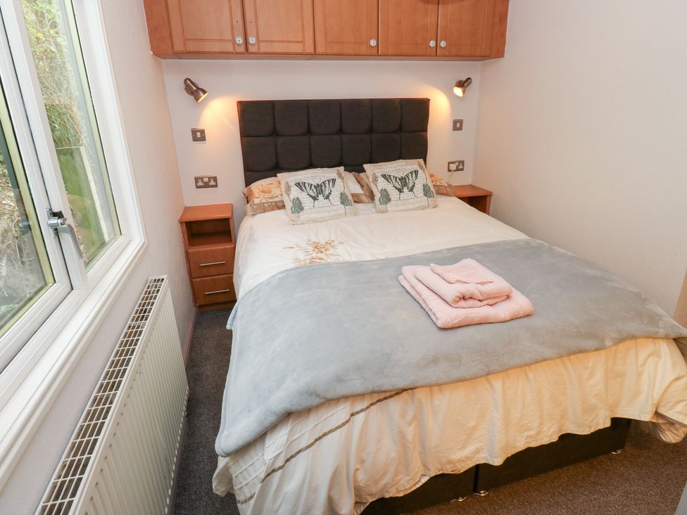 A bedroom with a bed, bedside table and window at John's Folly