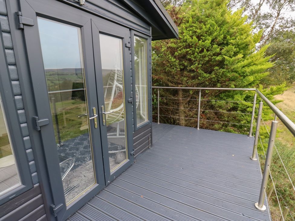 A deck with glass doors and railing at John's Folly