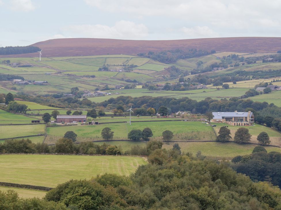 A landscape with hills, fields, and wind turbines at John's Folly in 