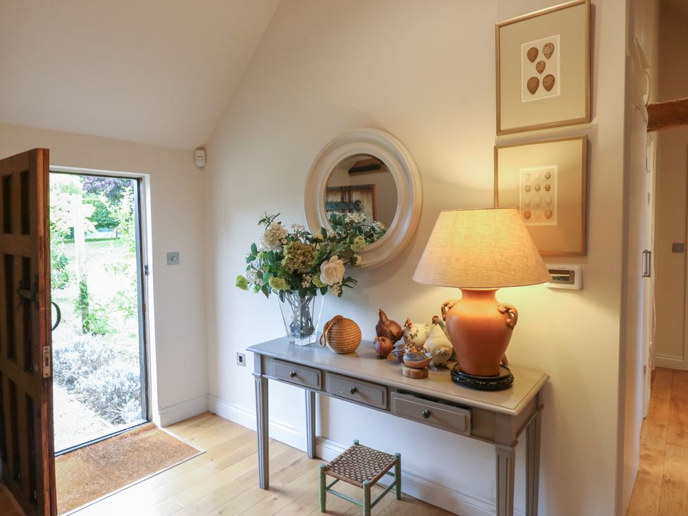 A hallway with a console table and flowers at The Piggery in Maidstone