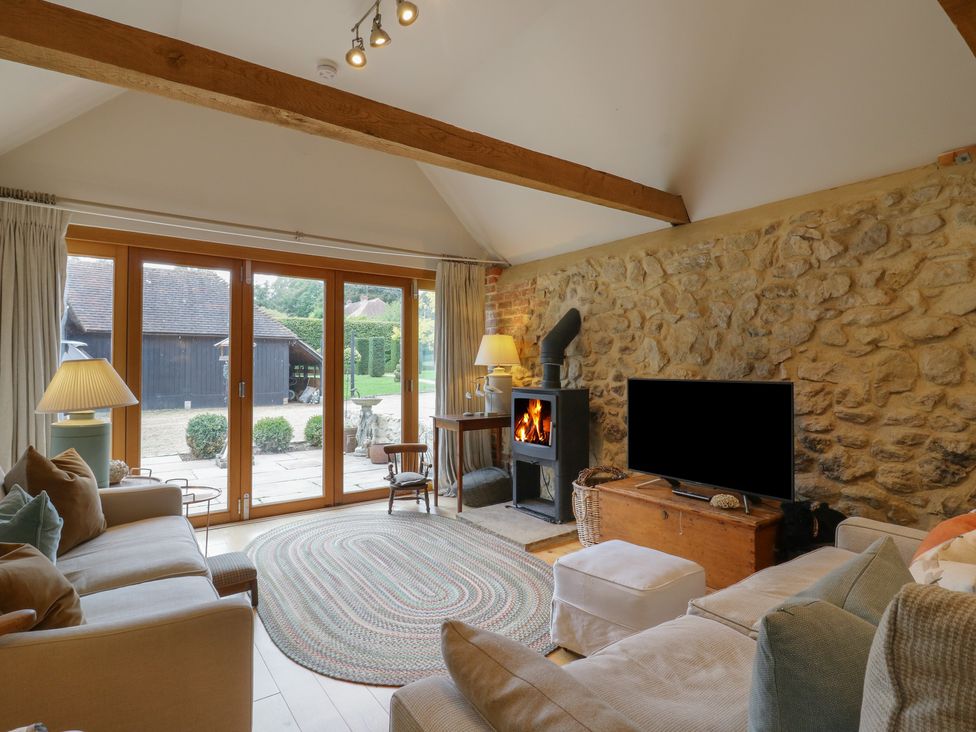 A living room with a fireplace and television at The Piggery in Maidstone