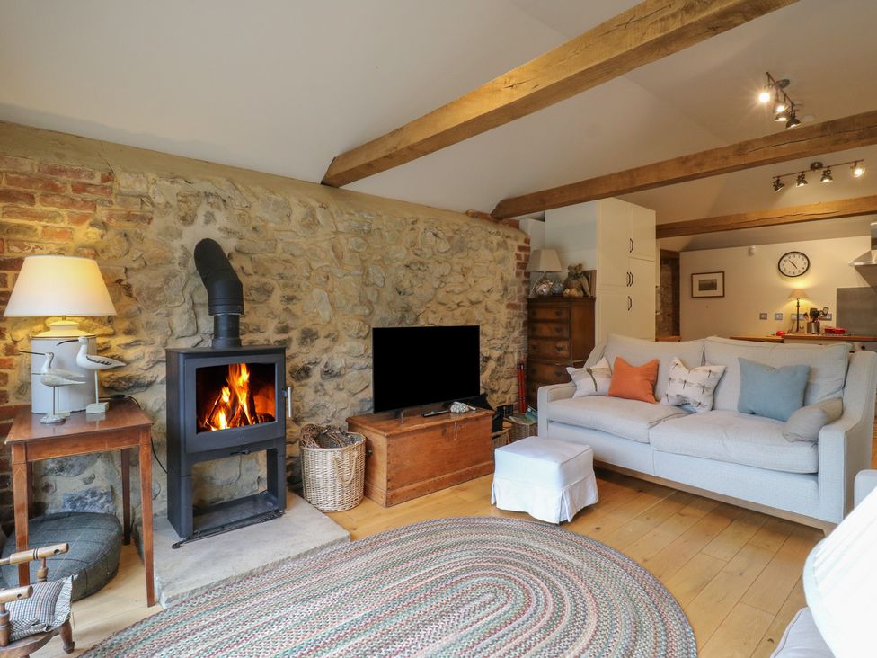 A living room with a fireplace and sofa at The Piggery in Maidstone