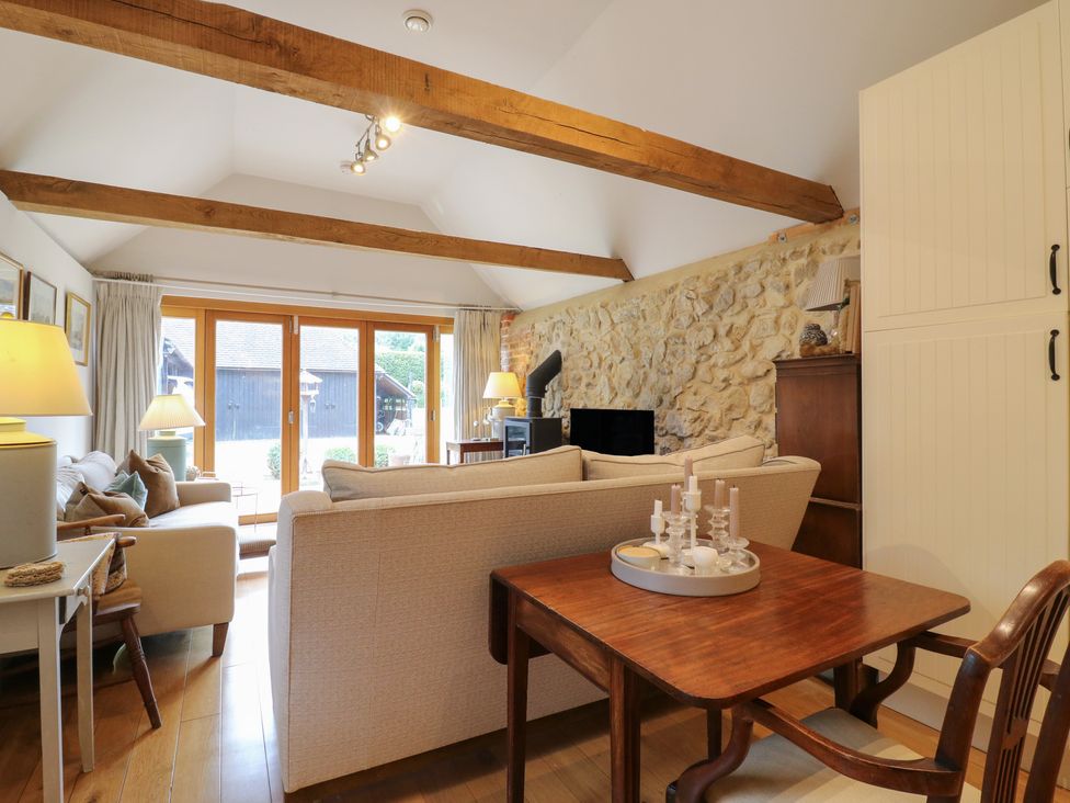A living room with a sofa and dining table at The Piggery in Maidstone