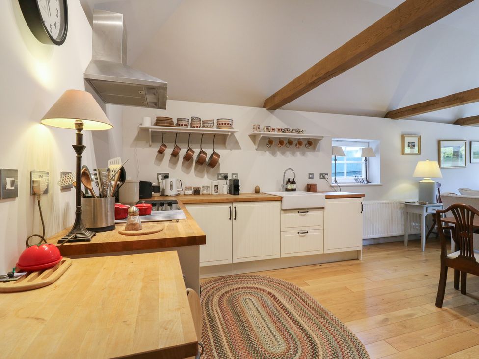 A kitchen with a sink, stove, and countertop at The Piggery in Maidstone