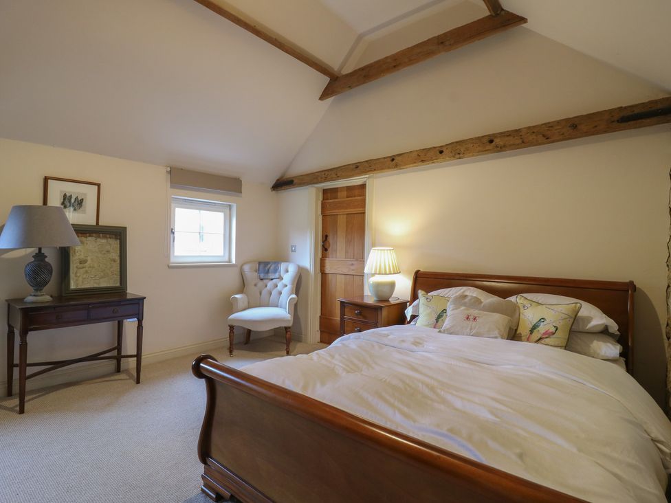 A bedroom with a bed and a lamp at The Piggery Maidstone