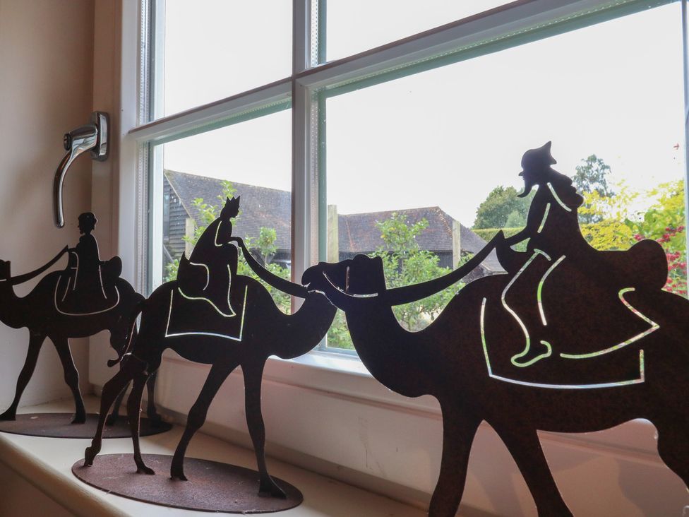 Silhouettes of figures riding camels by a window at The Piggery Maidstone