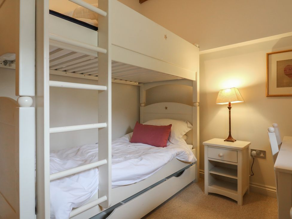 A bedroom with a bunk bed and a lamp at The Piggery in Maidstone