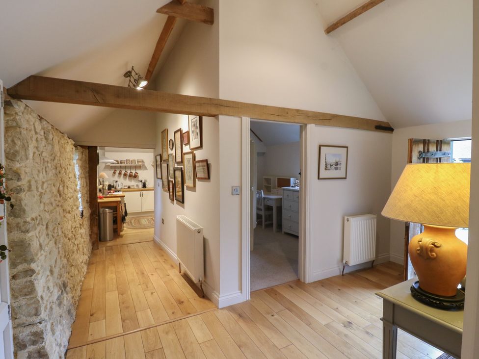 A hallway with wooden beams and a stone wall at The Piggery in Maidstone