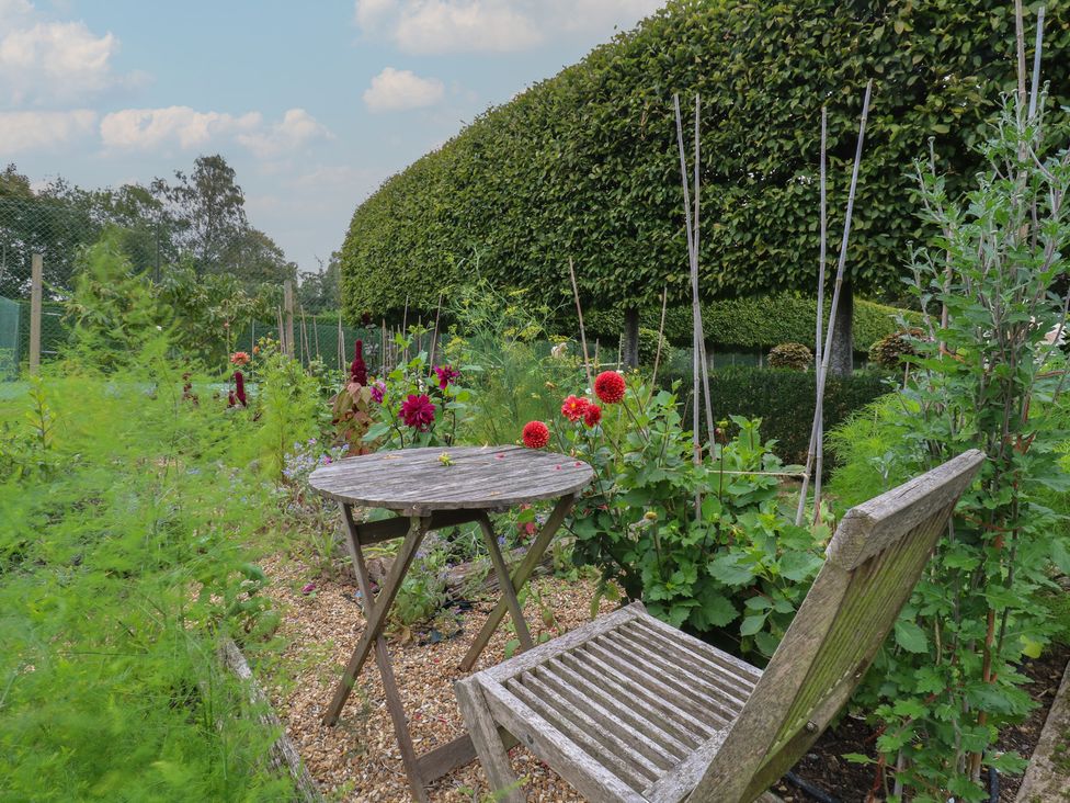 A garden with a table and chair surrounded by flowers at The Piggery Maidstone