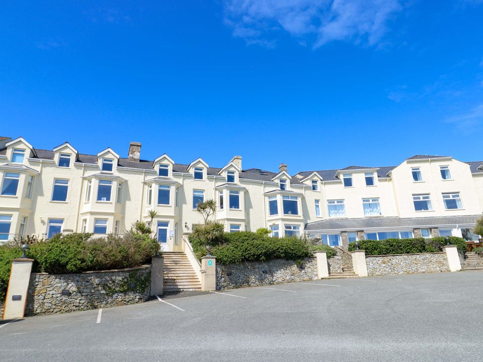 A building with windows and a parking lot at 19 Cliff Apartments in Trearddur Bay
