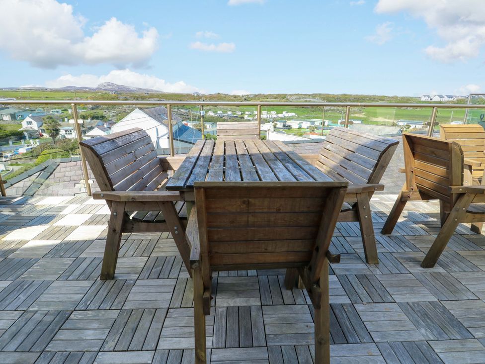 An outdoor patio with wooden furniture at 19 Cliff Apartments in Trearddur Bay