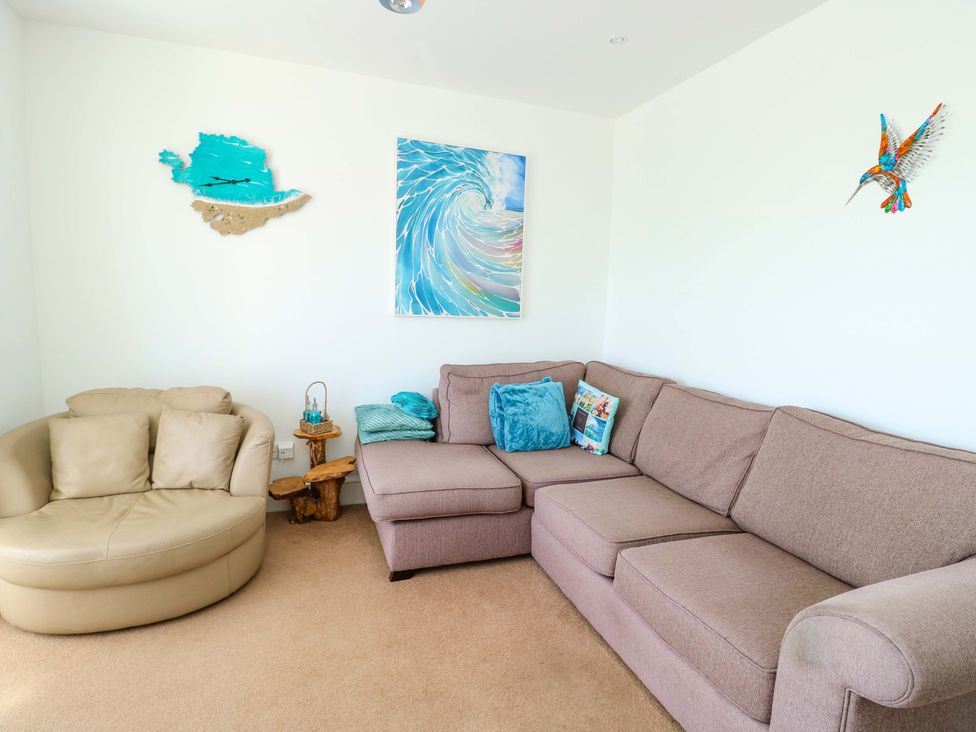 A living room with a sofa and decorative items at 19 Cliff Apartments in Trearddur Bay