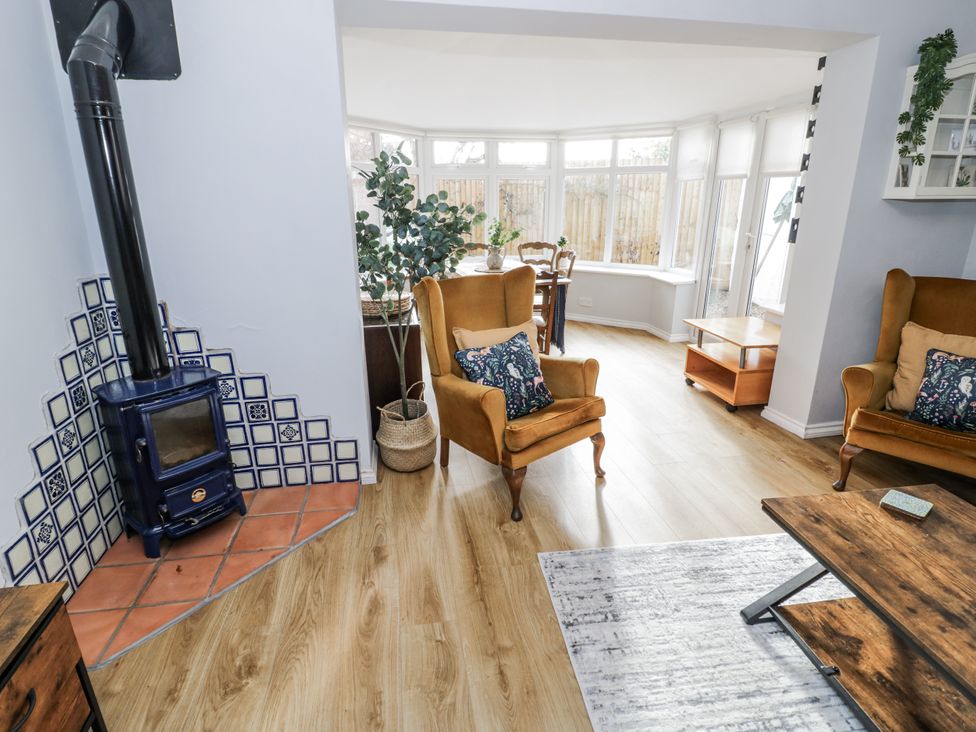 A living room with a wood stove and armchairs at 3 Leycester Court in Warwick