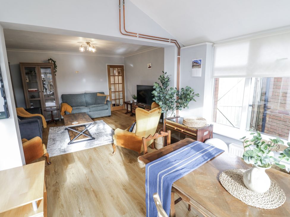 A living room with a sofa, coffee table, and dining table at 3 Leycester Court in Warwick