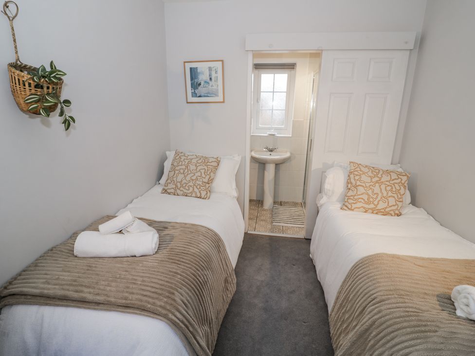 A bedroom with two beds and a sink at 3 Leycester Court in Warwick
