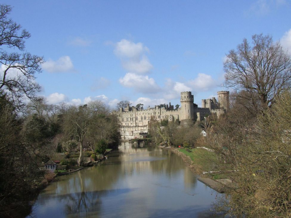 A view of a castle by a river at 3 Leycester Court in Warwick