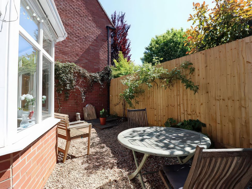 A garden with a table and chairs at 3 Leycester Court in Warwick