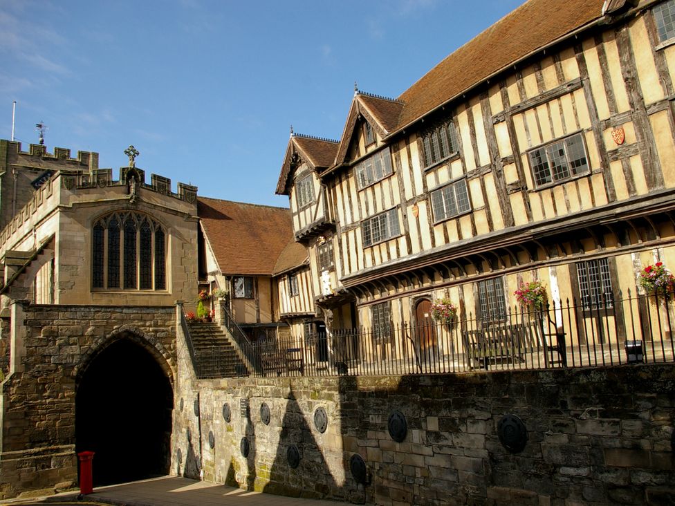 A historic building with a stone archway and wooden structure at 3 Leycester Court in Warwick
