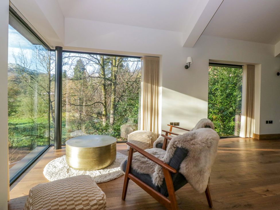 A living room with a coffee table and large windows at The Old Bunkhouse in Grasmere