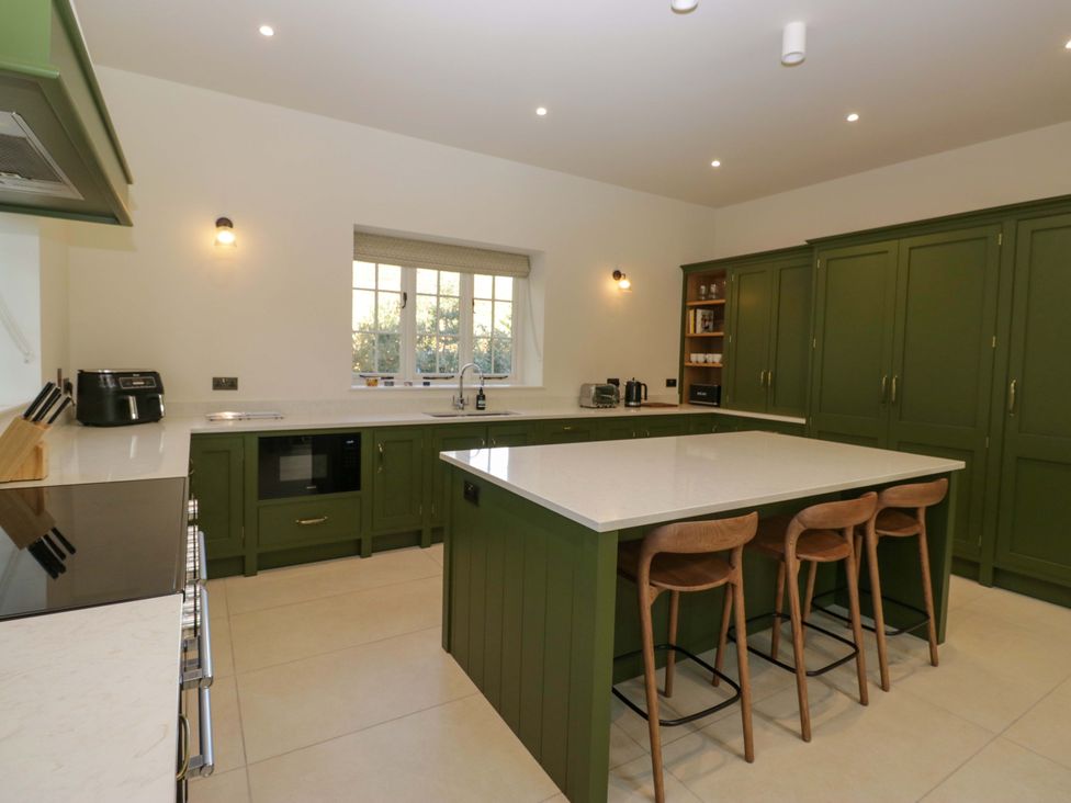 A kitchen with green cabinets and an island at The Old Bunkhouse in Grasmere