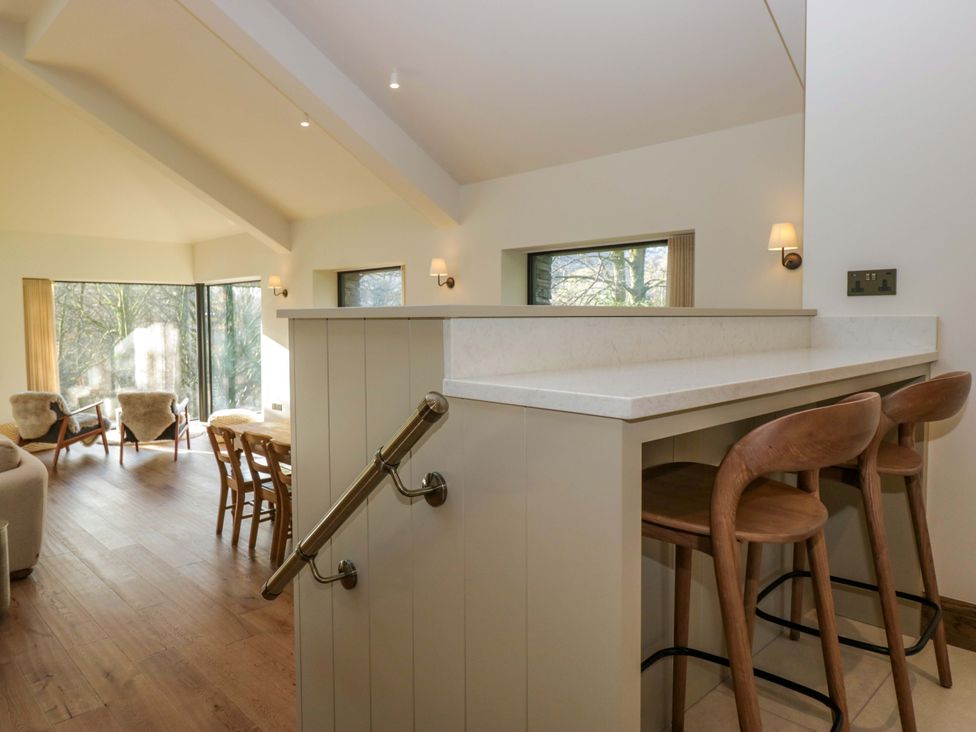 A living room with bar stools and a counter at The Old Bunkhouse in Grasmere