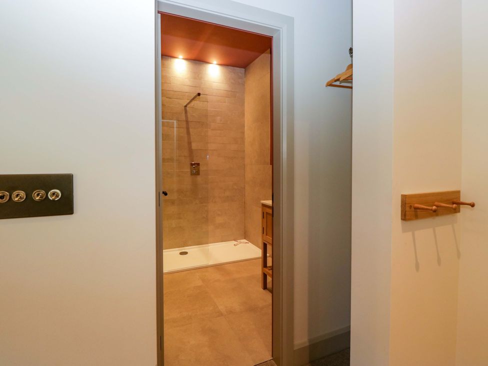 A bathroom featuring a shower and wooden hanger at The Old Bunkhouse in Grasmere