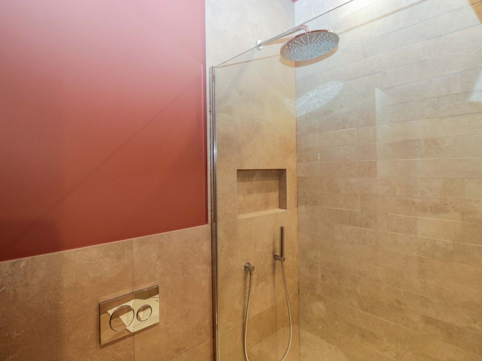 A shower area with a wall and niche at The Old Bunkhouse in Grasmere