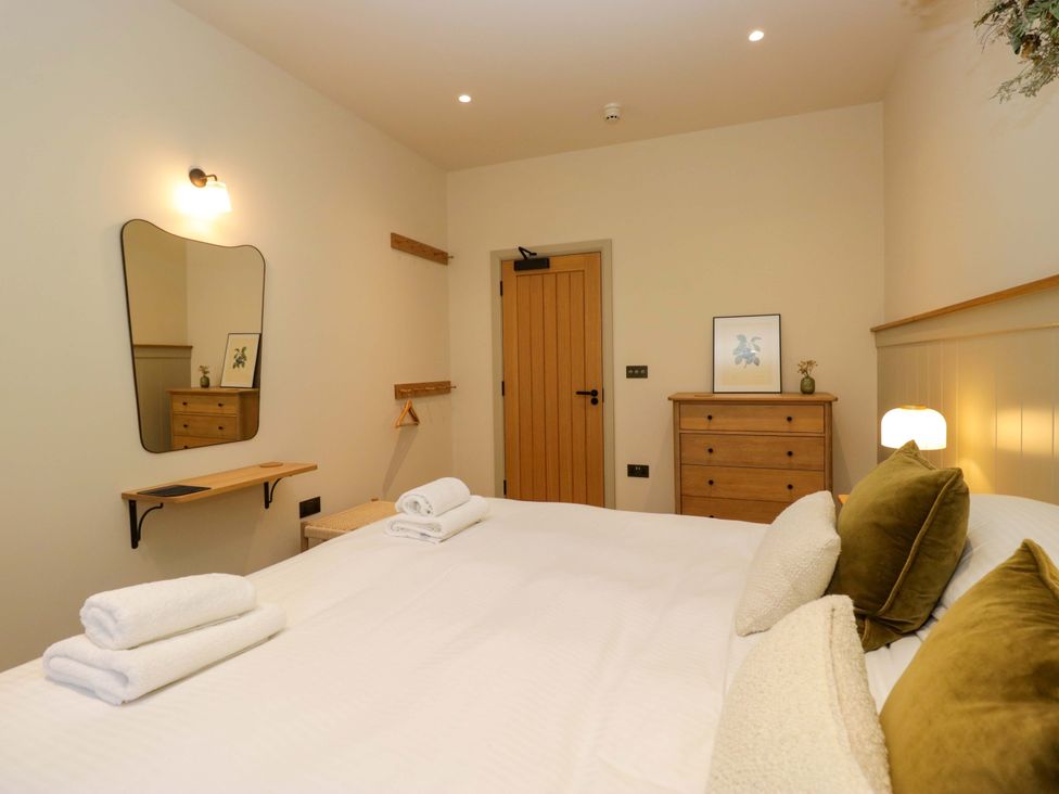 A bedroom with a bed and mirror at The Old Bunkhouse in Grasmere