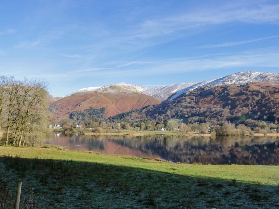 A landscape view of a lake surrounded by mountains and trees at The Old Bunkhouse in Grasmere