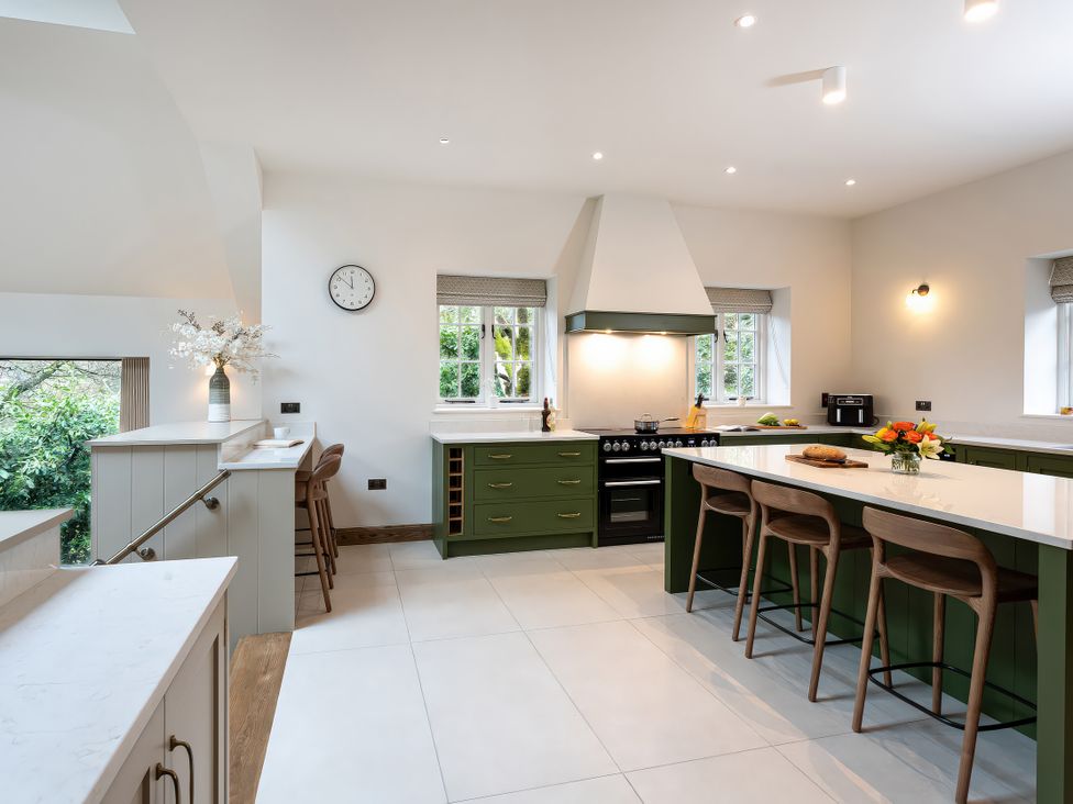 A kitchen with countertop and bar stools at The Old Bunkhouse in Grasmere