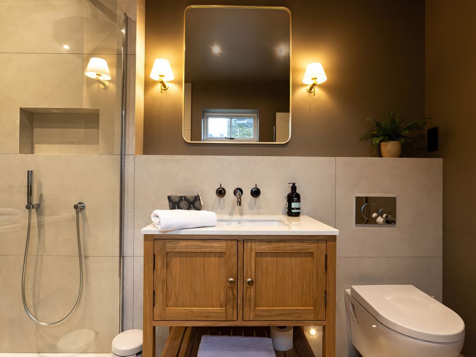 A bathroom with a shower, sink, and toilet at The Old Bunkhouse in Grasmere